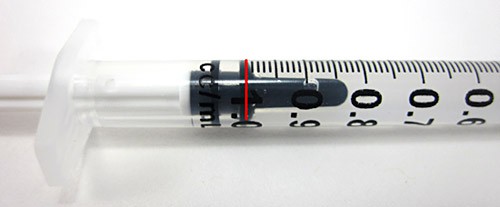 A plastic syringe is filled with water to the 1 mL mark