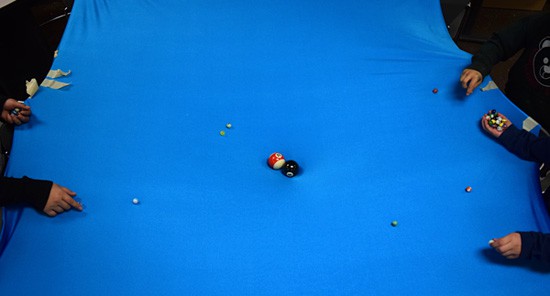 Two billiard balls at the center of a stretched blue sheet