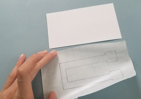 Demonstration of how the glossy temporary tattoo backing paper is smaller than the Con-Tact paper. 
