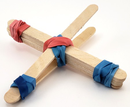 Another popsicle stick attached to the other side of the stack, and to one end of the launching stick with a rubber band