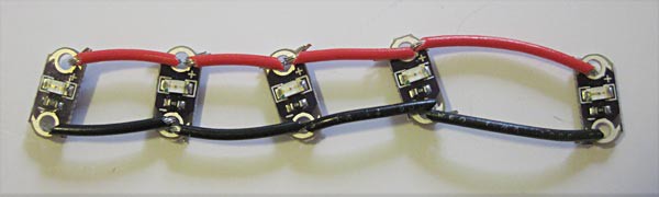 Four red wires and four black wires connect the positive and negative terminals of five LEDs
