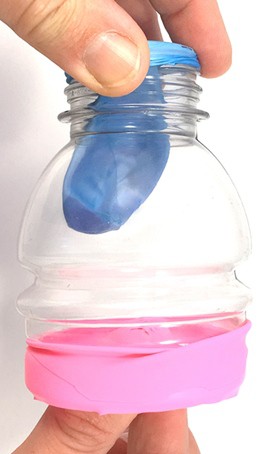 A lung model where a person pushes the knot in towards the model lung. The model lung is flat. 