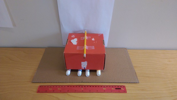 A cardboard box sitting on 4 markers