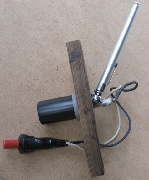 A push-button igniter, film canister, wooden board and pressure gauge are assembled
