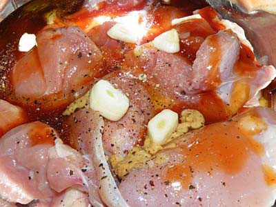 Raw chicken thighs are partially submerged in a liquid marinade