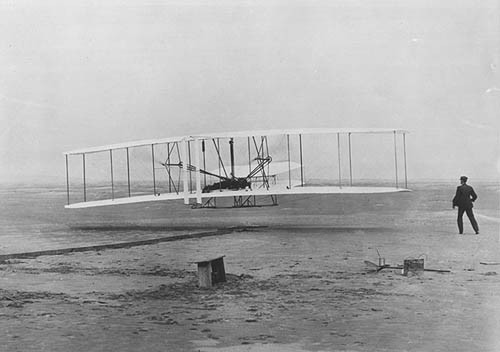 Black and white photo of the Wright Flyer in the air