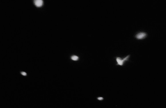 Several white dots forming a constellation on a black ceiling.