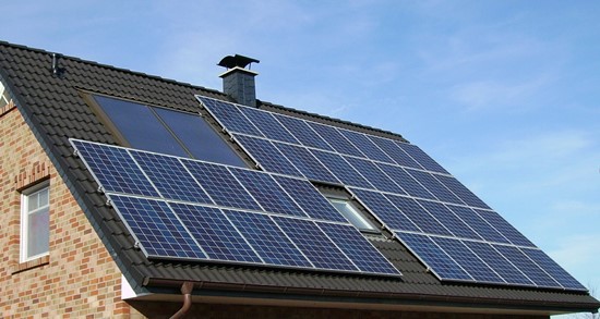  An array of solar panels on the roof of a house.
 