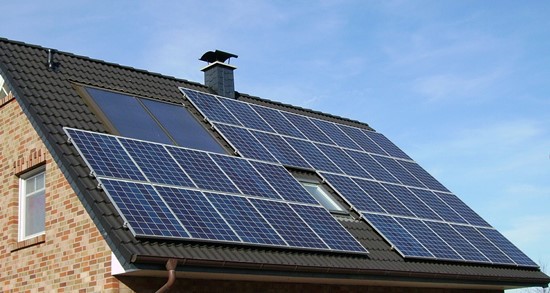 An array of solar panels on the roof of a house.