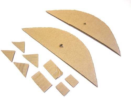 Four small triangles, two larger rectangles, two small rectangles and two parabolas cut from a sheet of cardboard