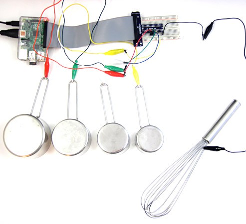 Alligator clips connect four metal pots and a metal whisk to a Raspberry pi board