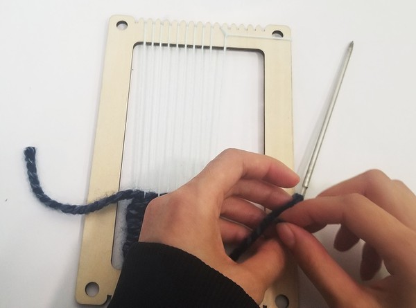 threading tapestry needle with leftover yarn. 