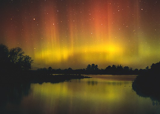 Photo of a red and yellow aurora spread across the night sky