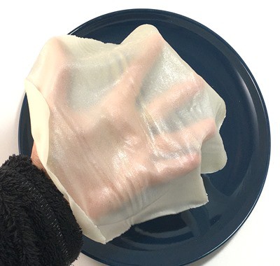 A sheet of thin translucent edible paper on a hand.