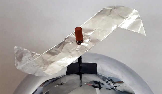 A rotor made from aluminum foil with pointed tips, mounted on a nail on top of a van de graaff generator. 