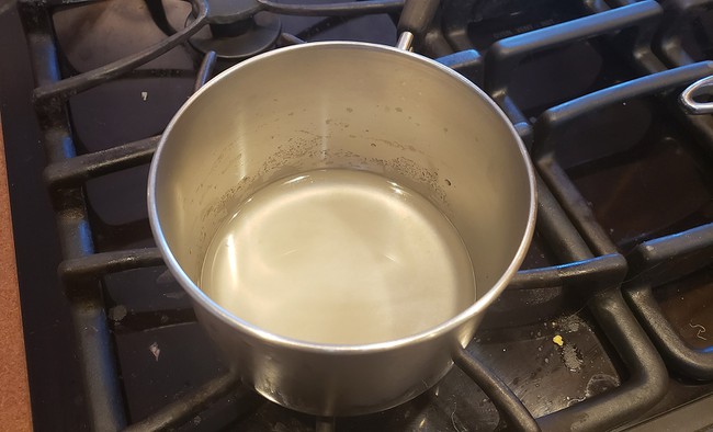 Cloudy agar-agar solution in a pot on a stove 