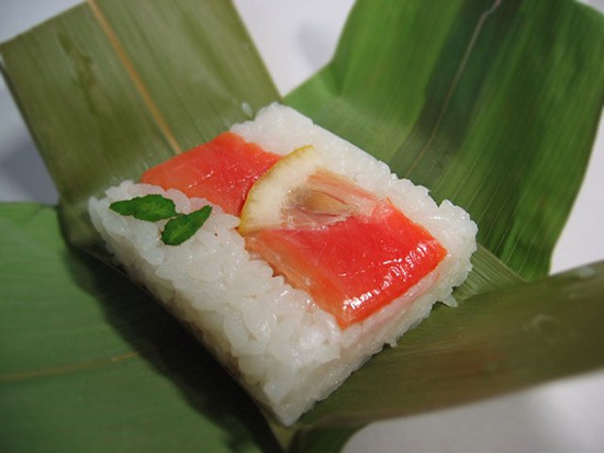 Sushi with garnish wrapped in bamboo leaves