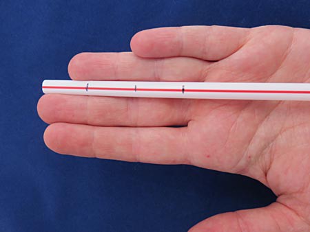 Three horizontal marks are made across a plastic straw that align with the joints in a human finger