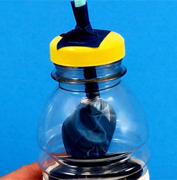 A balloon is taped over the end of a straw and inserted into a plastic bottle through the bottle cap