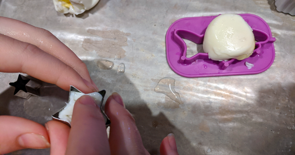 Student pressing a hard boiled egg into a cookie cutter shape form