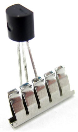 A single lead of an electronic component is inserted into a breadboard spring clip