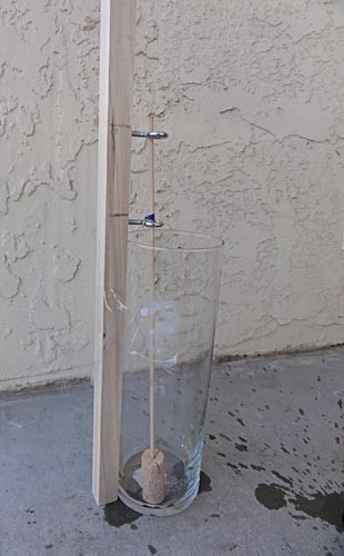 A wooden skewer with a cork at one end resting in a beaker