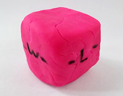 Play-Doh cube labeled with dimensions