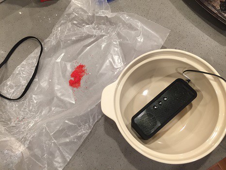 Red sand on wax paper and a speaker in a bowl.