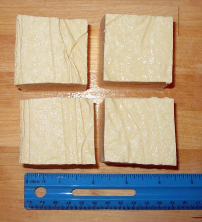A block of white tofu is cut into four equal cubes