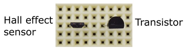 Top-down view of a hall effect sensor and transistor inserted into a breadboard