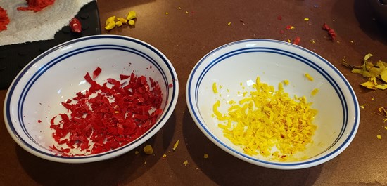 Different color crayon shavings in two different bowls.