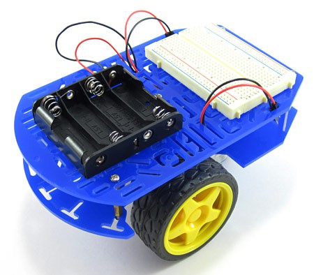 An assembled chassis with a breadboard and battery pack for a light-following robot