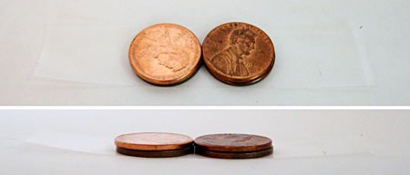 Two stacks of two pennies lay on a piece of tape next to each other