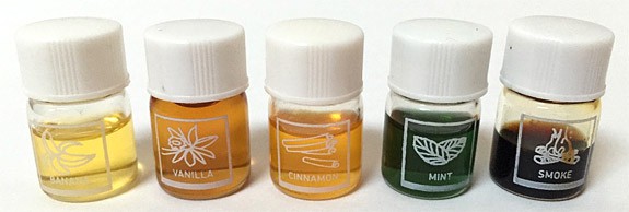 Five vials of concentrated scent solutions of banana, vanilla, cinnamon, mint and smoke
