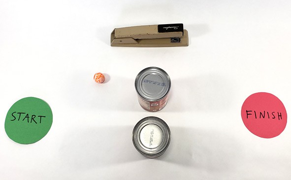 A stapler and two cans of food stand between two circles labeled start and finish