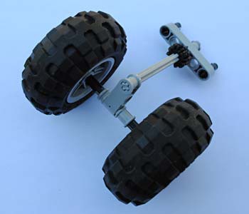 Two LEGO wheels on an axle connect to a spinning vertical shaft