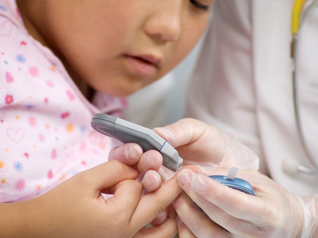 Educator and child doing blood sugar test