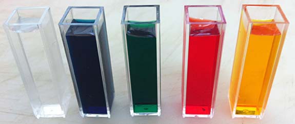 Five cuvettes filled with water with four being colored with food coloring (blue, green, red and yellow)