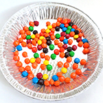 Colorful candies in a tray for a game to explore camouflage as a protective strategy found in nature