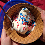 Waffle cone full of ice cream made in a bag and decorated with red and blue sprinkles for 4th of July