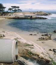 A storm drain pipe emptying near a beach