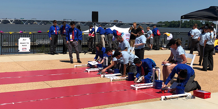 Students place solar-powered cars on a test track