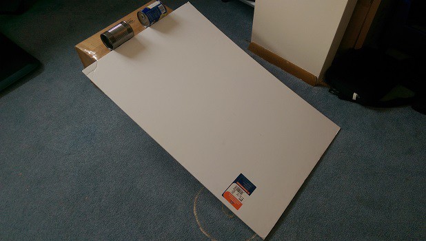 A ramp made with a posterboard and a box, with cans getting ready to race at the top