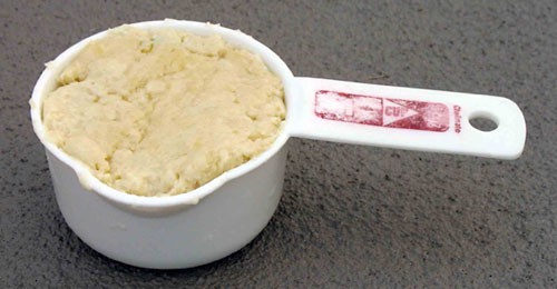 Dough is packed into a 1-cup measuring cup