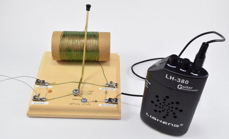 Photo of a complete homemade crystal radio circuit connected to a handheld audio amplifier