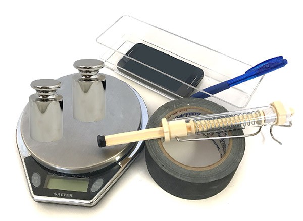 A scale, spring scale, plastic container, smartphone, tape and weights
