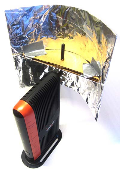 A wireless router's antenna is inserted into the focal point of a homemade parabolic reflector