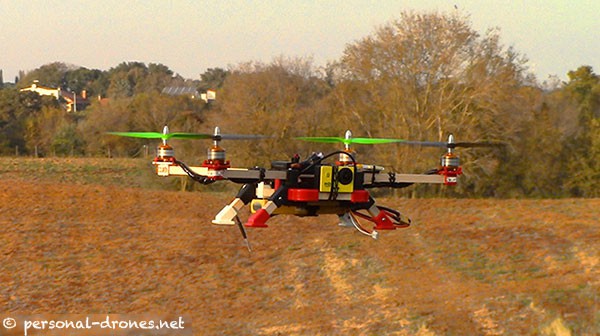 Agricultural drone hovering over a brown farm field. 
