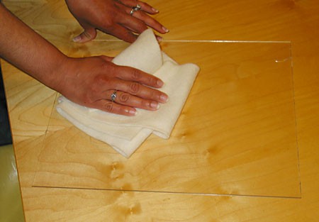 Using a piece of wool to clean an acrylic sheet