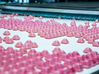 Sweets factory. Sweets production process. Conveyor belt with sweets on it.